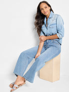 Light blue denim shirt, Western-style pockets, long sleeves. Model wears light wash jeans and light brown sandals.