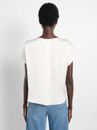 Off-white woven top, short sleeves, boat neck.  Rear view.