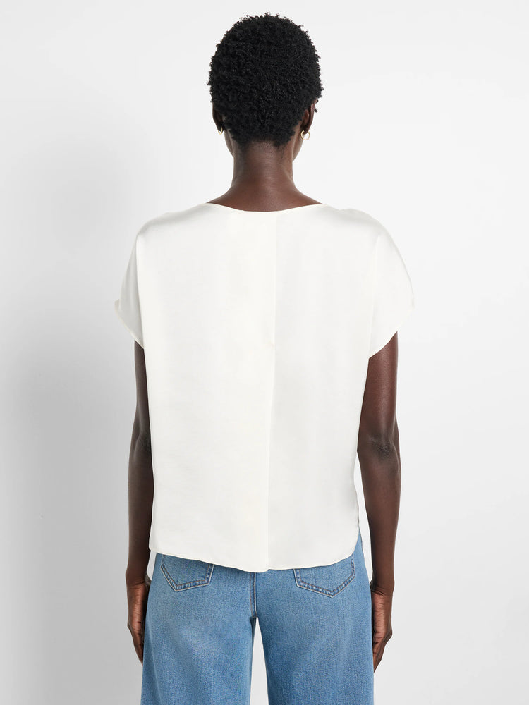 Back view of an off-white, glossy woven tee with cap sleeves and a center back seam.