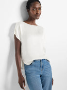 Ivory woven tee with a boat neck, short dolman sleeves, and relaxed fit. Features a subtle gloss fabric.