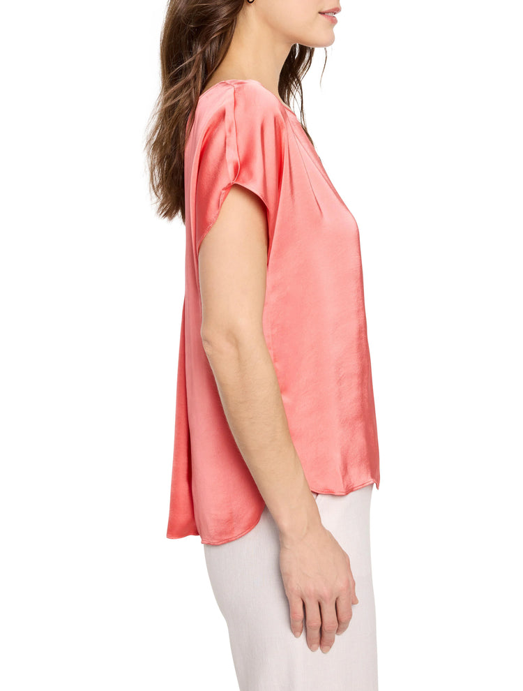 Glossy coral woven tee with a relaxed fit and short, draped dolman sleeves on a model's side profile.