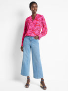 Pink long-sleeve blouse with red & blue abstract print.  Collared.