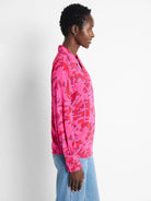 Pink long-sleeve blouse with red and blue abstract print.  Collared, button-front.