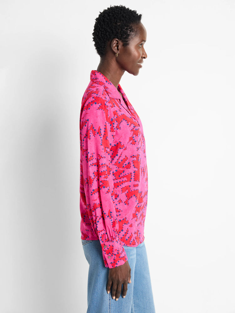Pink long-sleeve blouse with red and blue abstract print.  Collared, button-front.