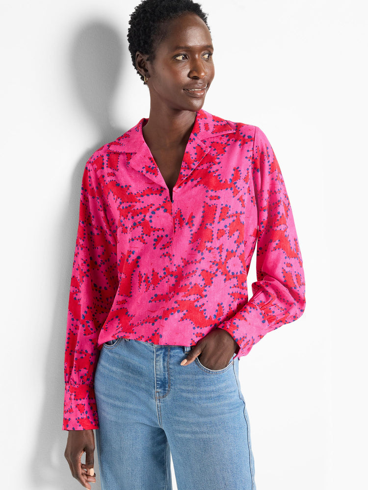 Pink long-sleeve blouse with red and dark blue abstract print. Collared, button front.