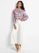Pink, blue, and purple abstract floral print woven top with long sleeves and V-neck.
