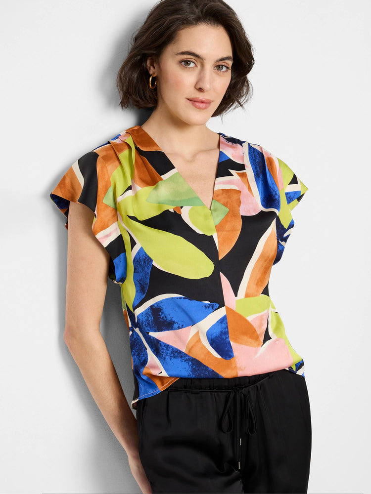 Black top with abstract colorful leaf print in blue, orange, pink, and lime green. Short flutter sleeves. V-neck.