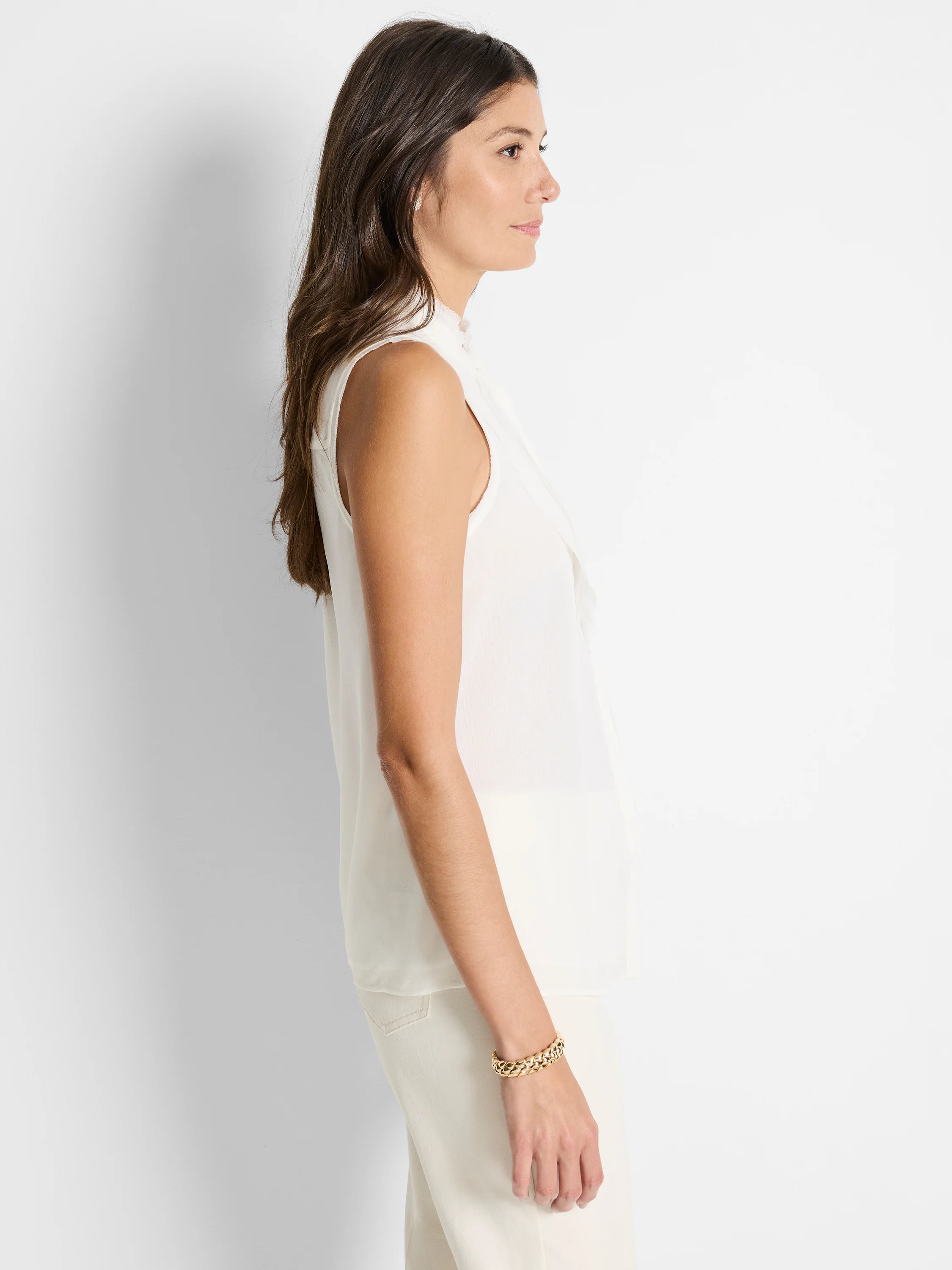 Off-white sleeveless woven tank top;  slightly ruffled neckline.