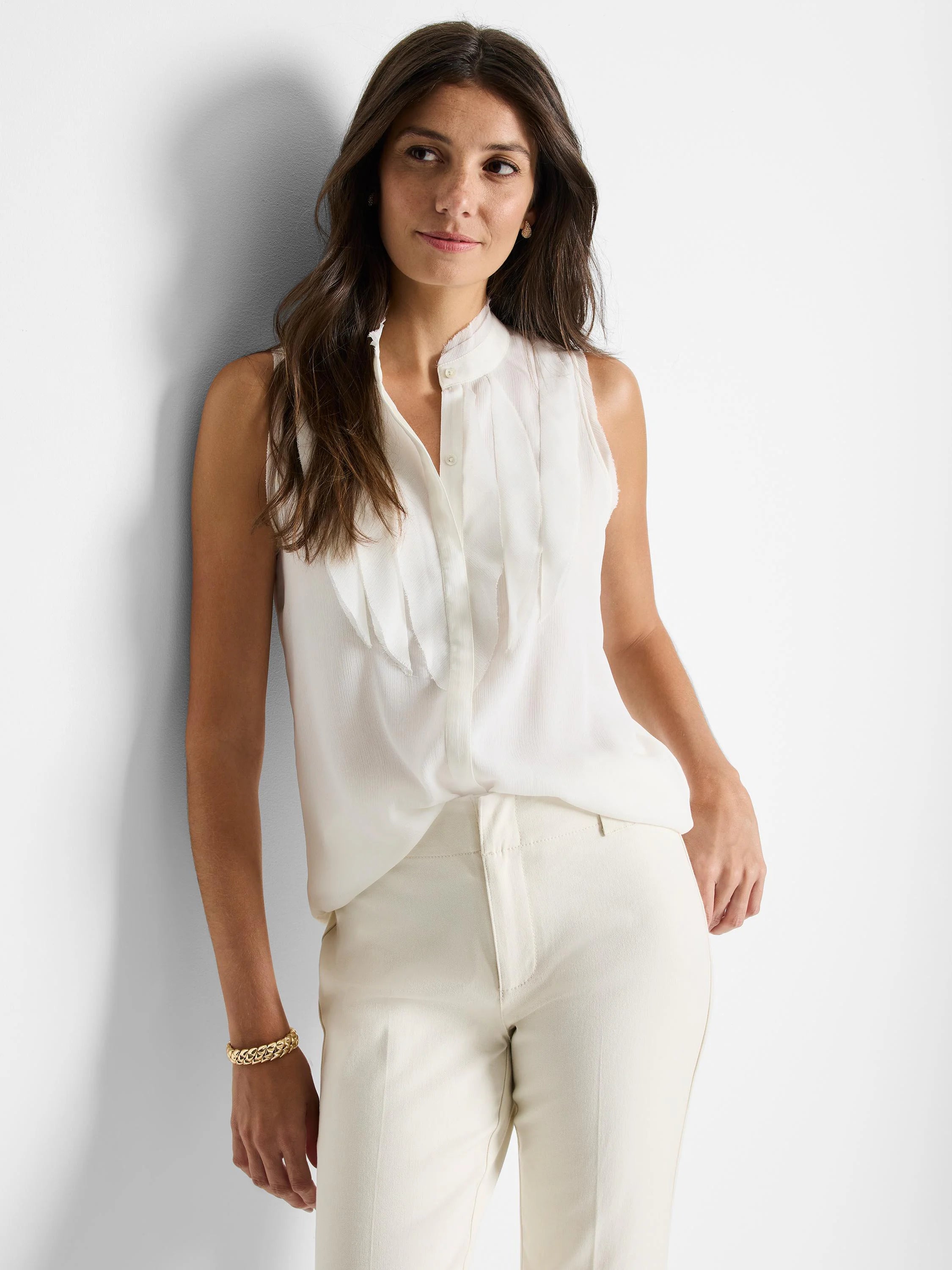 Off-white sleeveless woven top with ruffled detail at the neckline and button front closure.