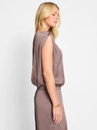 Mauve-colored sleeveless top with ruched shoulders and an elasticized waist.  Side profile shown.