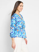 Blue, white, and brown mosaic-patterned wrap top with 3/4 sleeves and cinched waist.