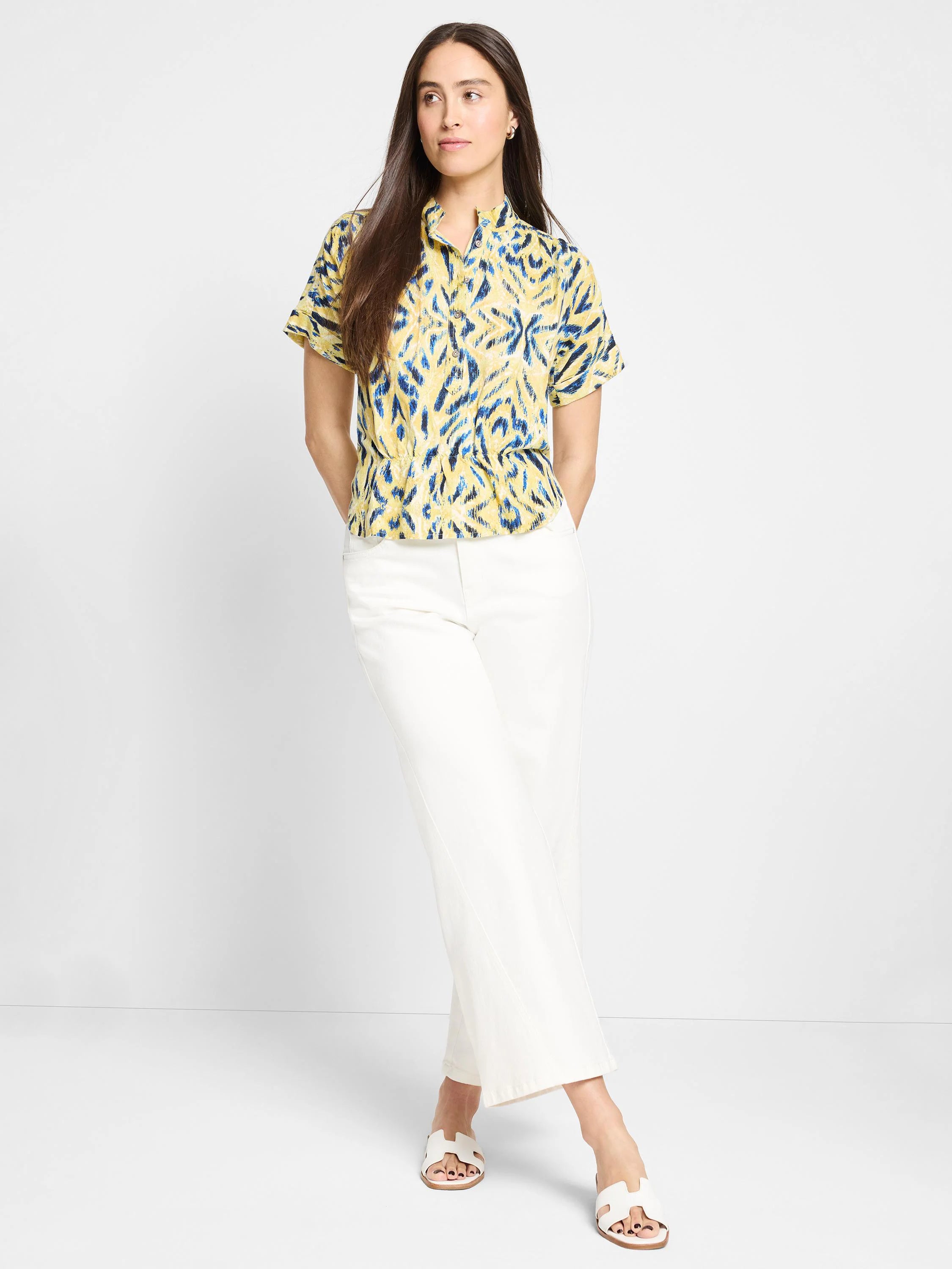 Yellow short-sleeved shirt with blue abstract print, collared.