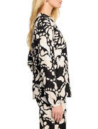 Black long-sleeved shirt with beige abstract floral print.