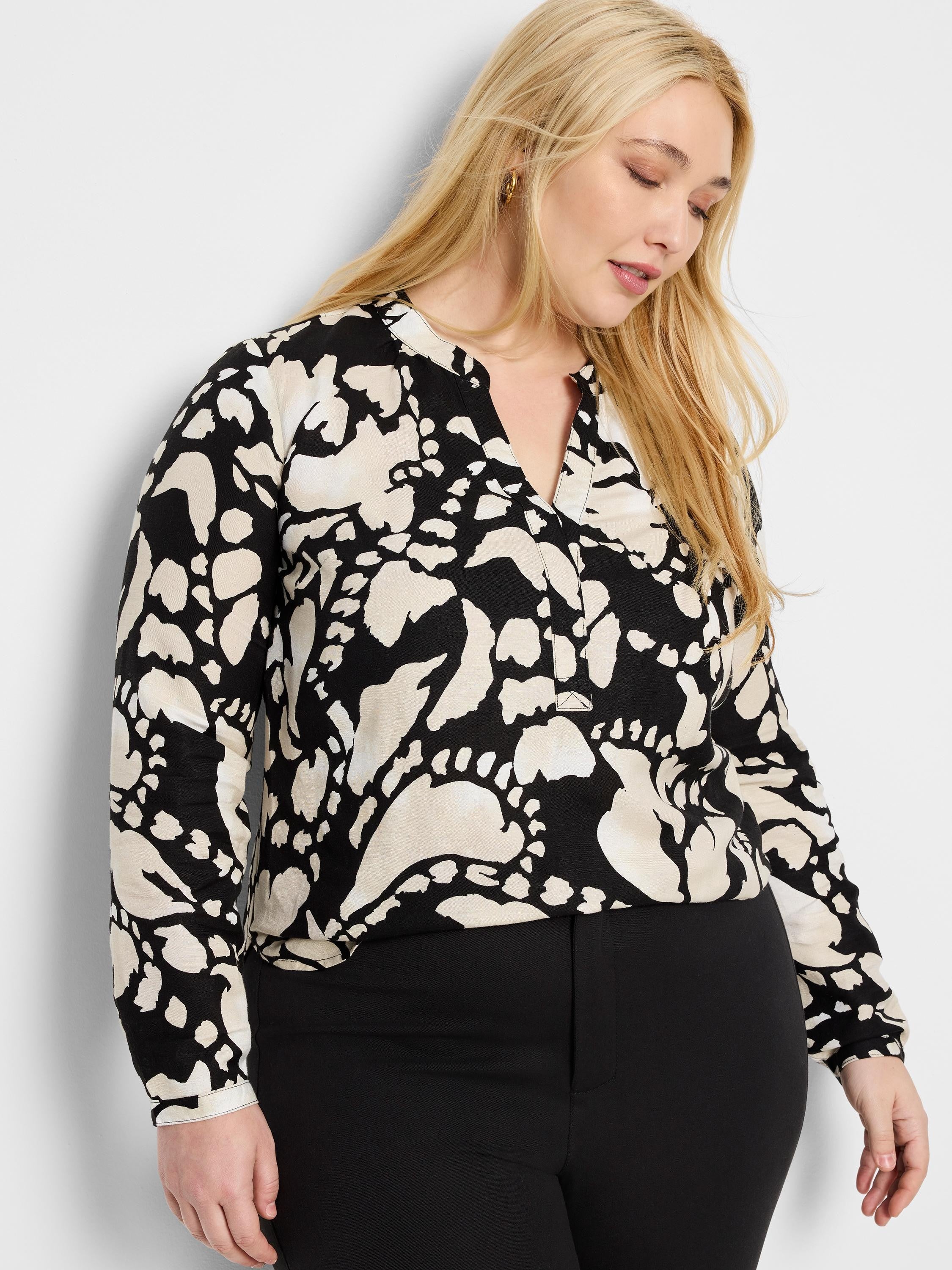 Black long-sleeve shirt with beige abstract print, V-neck.