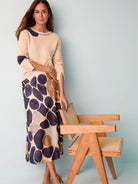 Mid-length slip skirt with an abstract pebble print in shades of beige, brown, and dark purple on a cream background.