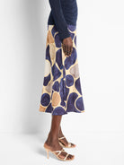 A-line midi skirt in beige with an abstract print of dark blue and brown pebbles.