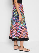 A-line midi skirt with a multicolored, diagonal pattern on a black background.  Colors include pink, teal, brown, and...