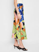 Midi slip skirt, A-line, black background, abstract floral print in blue, orange, green, and pink.