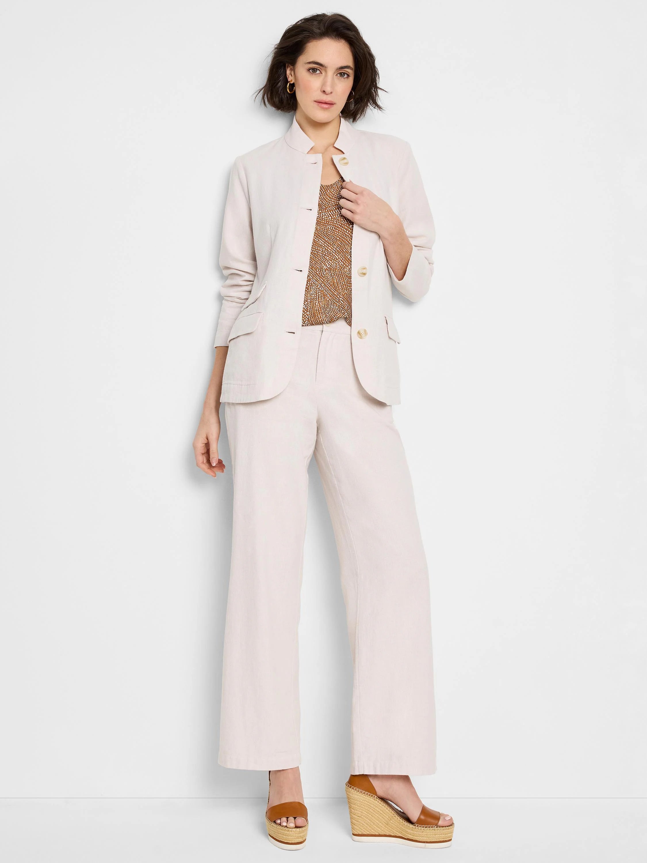 Off-white wide-leg linen-cotton pants on a model.  The pants are shown with a matching off-white jacket.