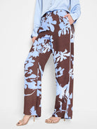 Brown wide-leg pants with a light blue floral print and a subtle side stripe.
