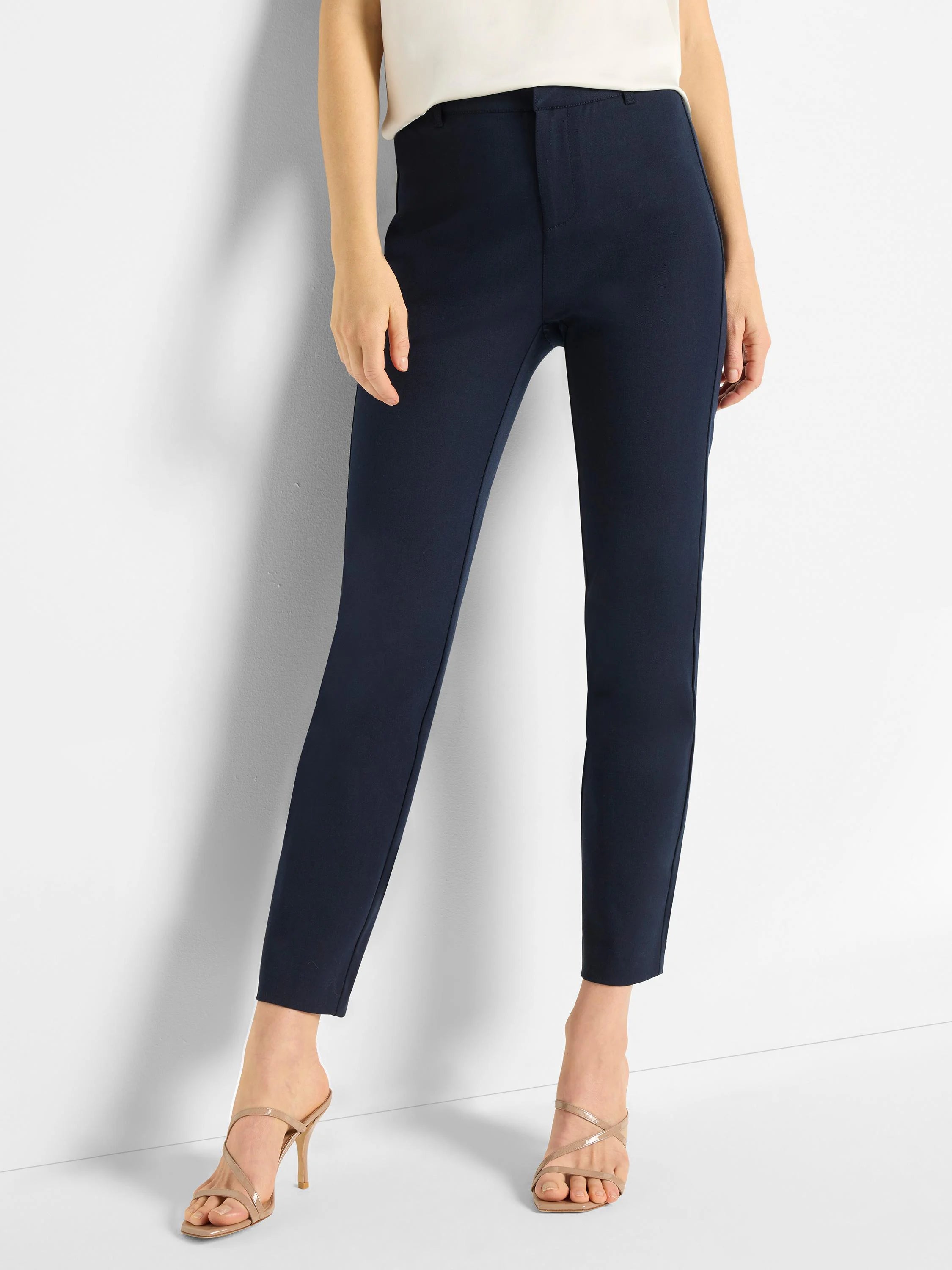 Smooth navy blue straight-leg pants with a flat front, cropped at the ankle, worn by a model.