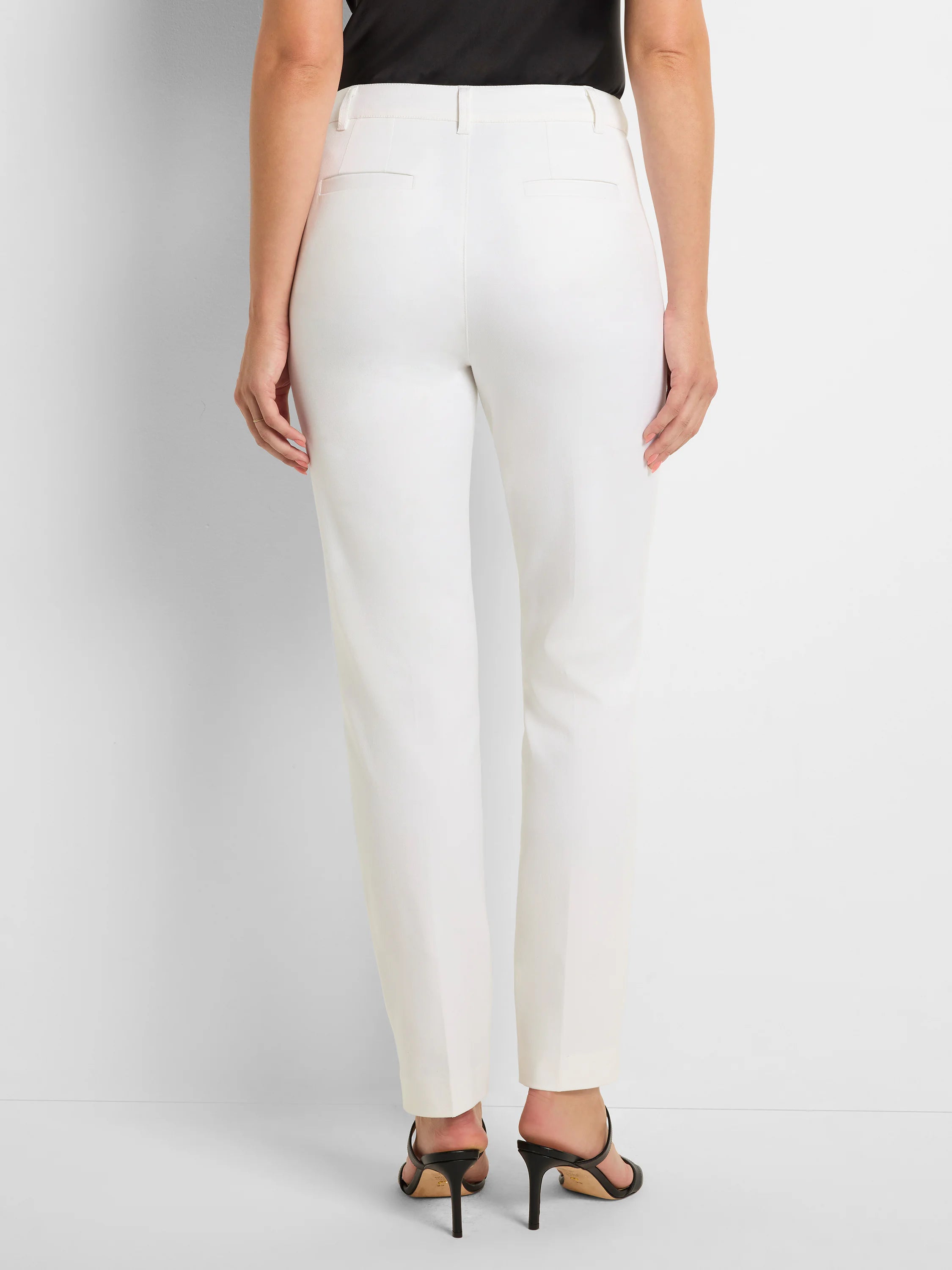 Rear view of white straight pants with belt loops and two horizontal back welt pockets.