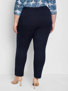 Dark navy blue straight pants with rear patch pockets, worn ankle-length.