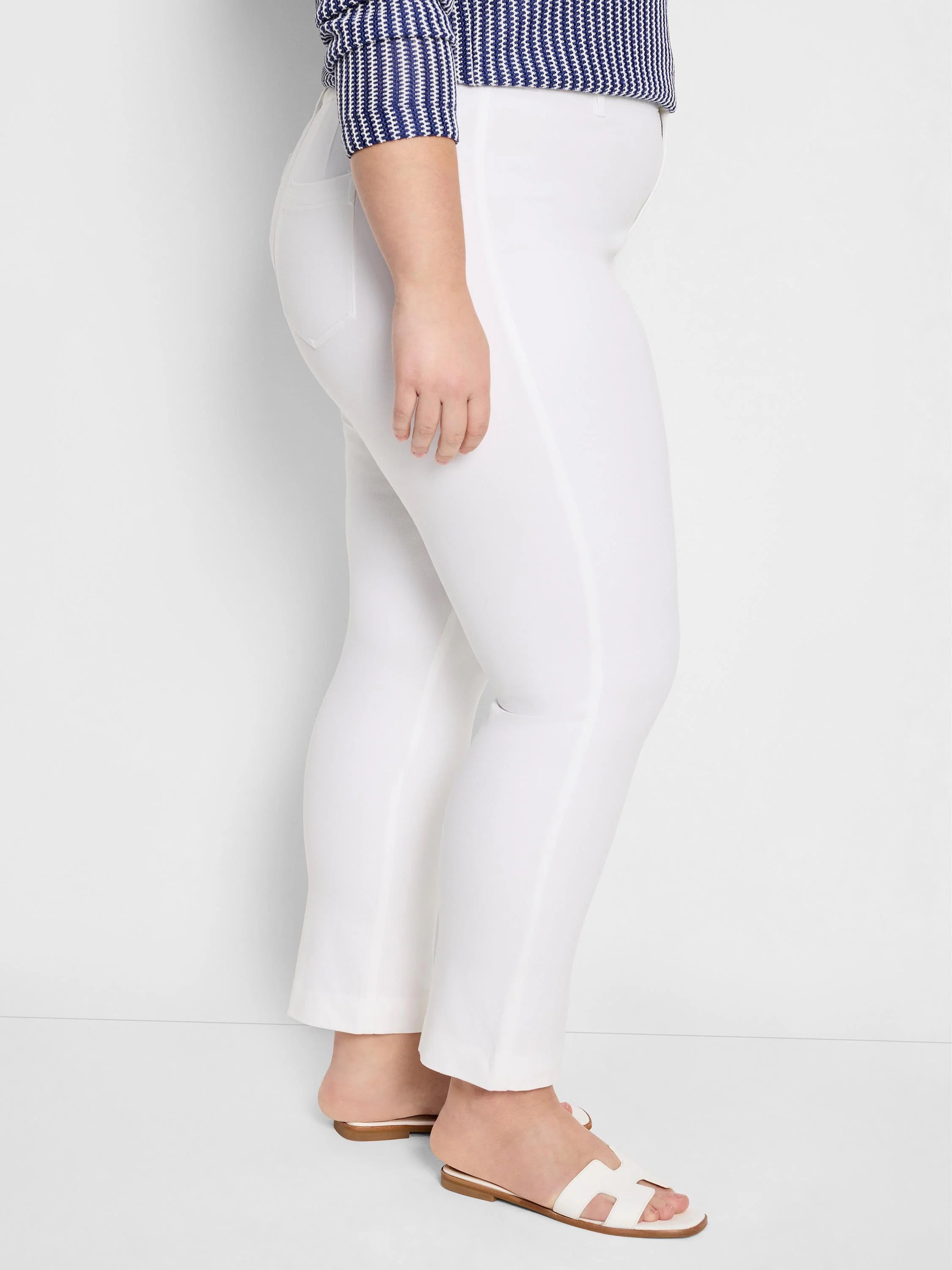 White straight-leg pants with a smooth texture, ending above the ankle, worn by a model.