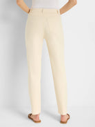 Cream-colored straight-leg jeans, back view.  Features include back pockets.