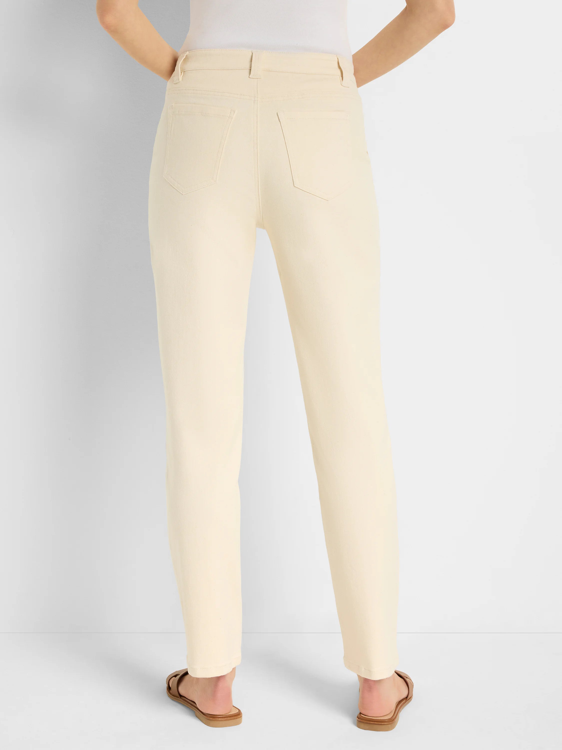 Cream-colored straight-leg jeans, back view.  Features include back pockets.