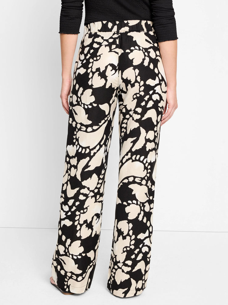 Black wide-leg pants with a beige floral pattern.  Elastic waistband.