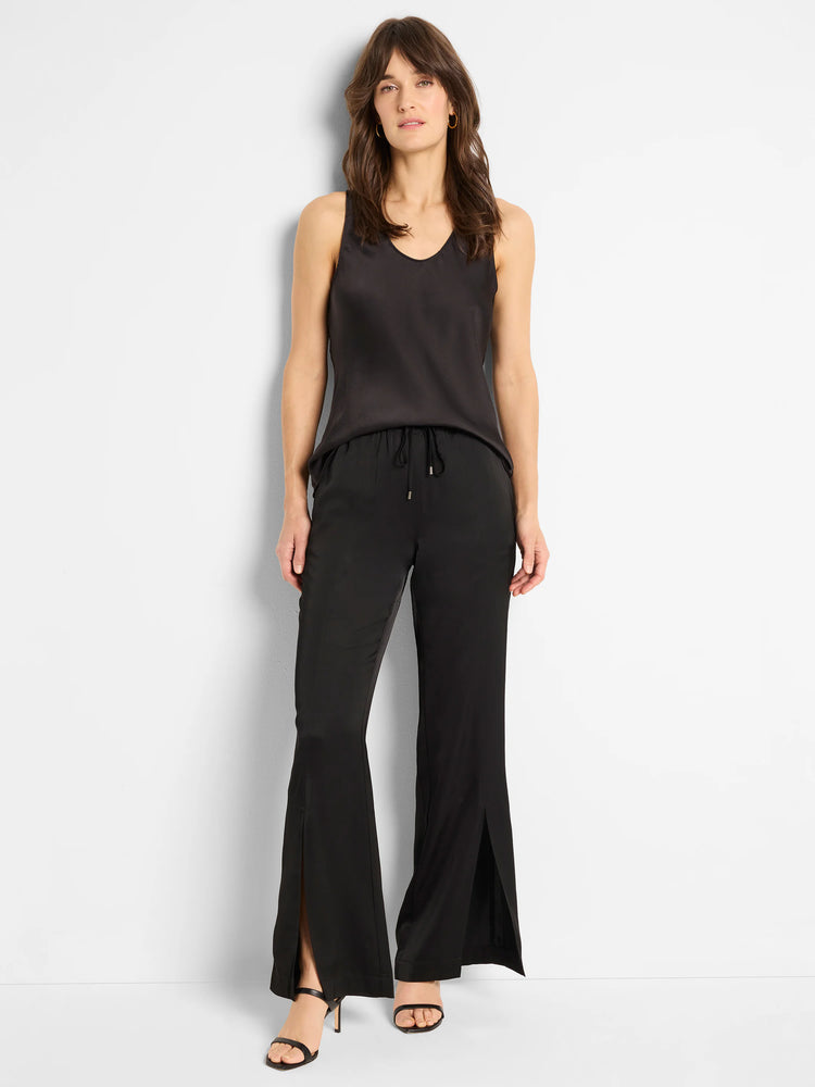 Black, wide-leg pants with front slits and an elastic waistband.  Model wears them with a black camisole.