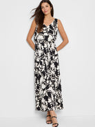 Black sleeveless maxi dress with off-white floral pattern, belted waist.