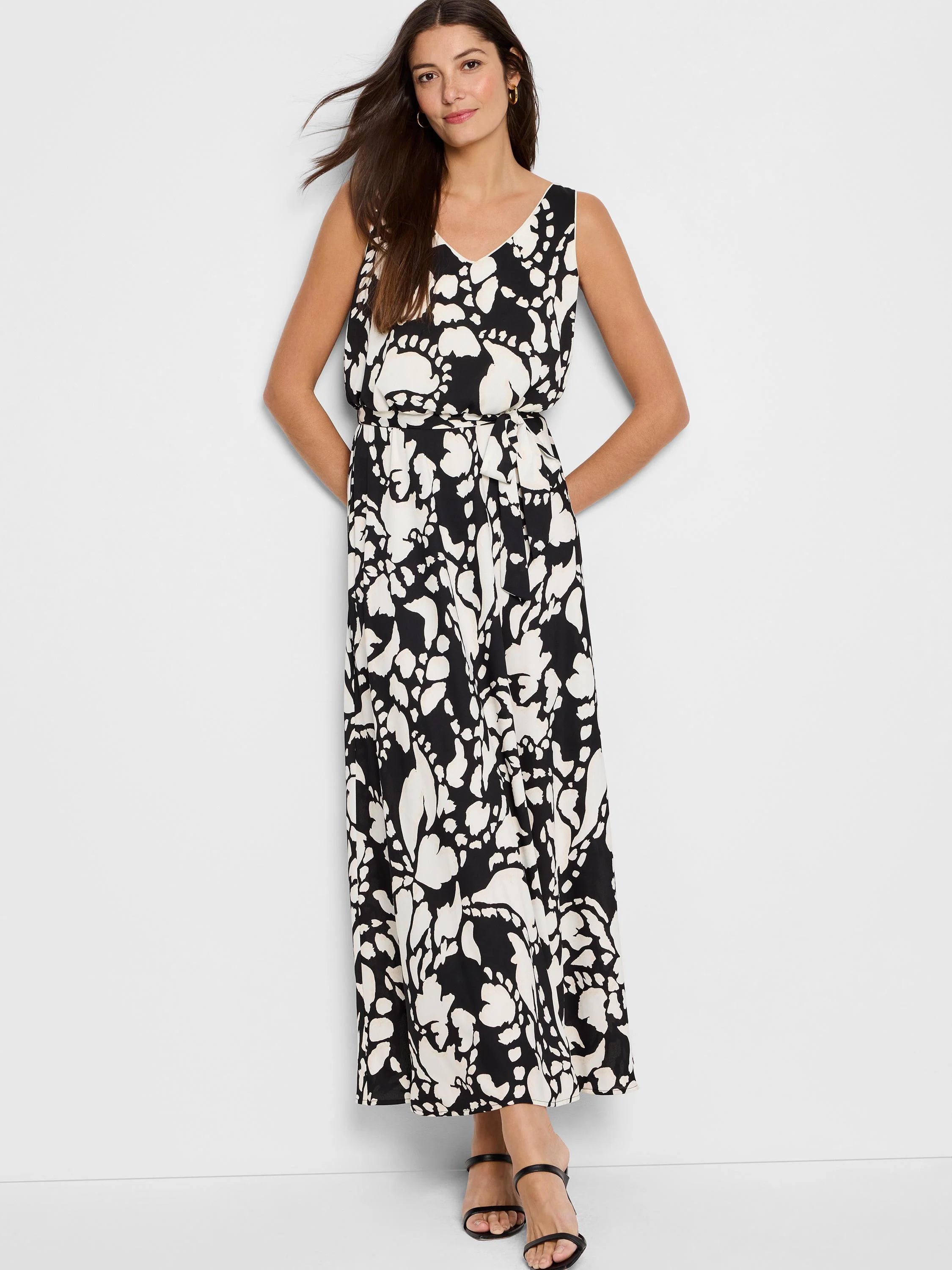 Black sleeveless maxi dress with off-white floral pattern, belted waist.