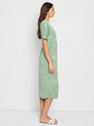 Light green midi dress with a white abstract print, short sleeves, and a fitted waist.