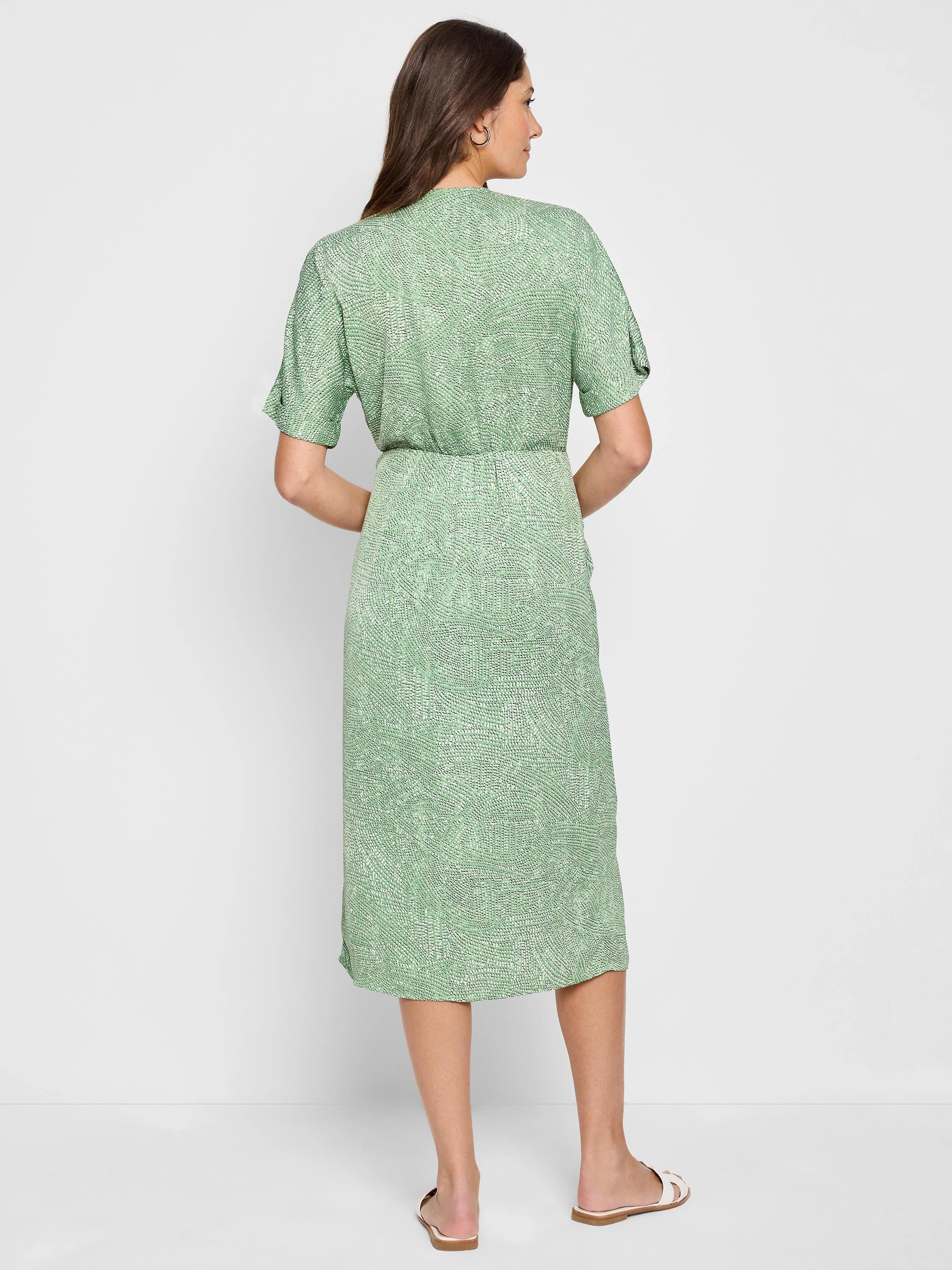 Sage green midi wrap dress with a light abstract print. Short sleeves. Shown from the back.