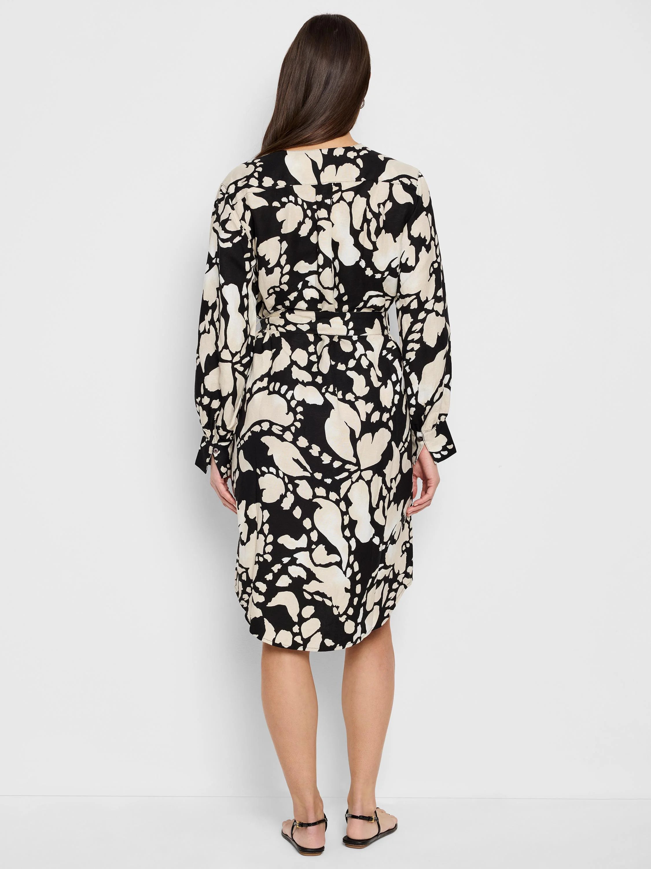 Black midi dress with beige abstract print, long sleeves, and a belted waist.