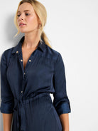 Navy blue, crinkled satin shirt dress with gold buttons,  long sleeves, and a drawstring waist.