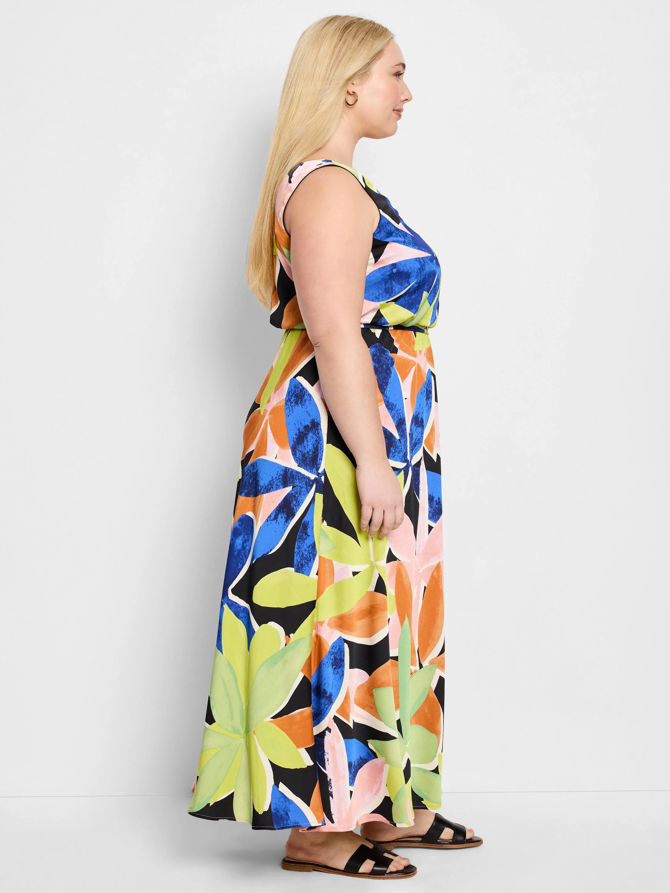 Sleeveless maxi dress with a large abstract floral print in blue, orange, pink, lime green, and black on a black background.