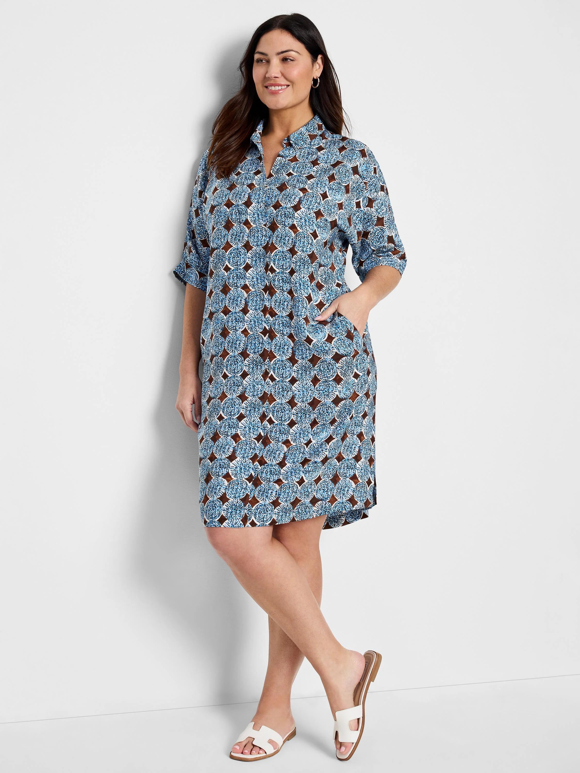 Blue midi dress with brown and white circular pattern, collared neckline, and short sleeves.  Has pockets.