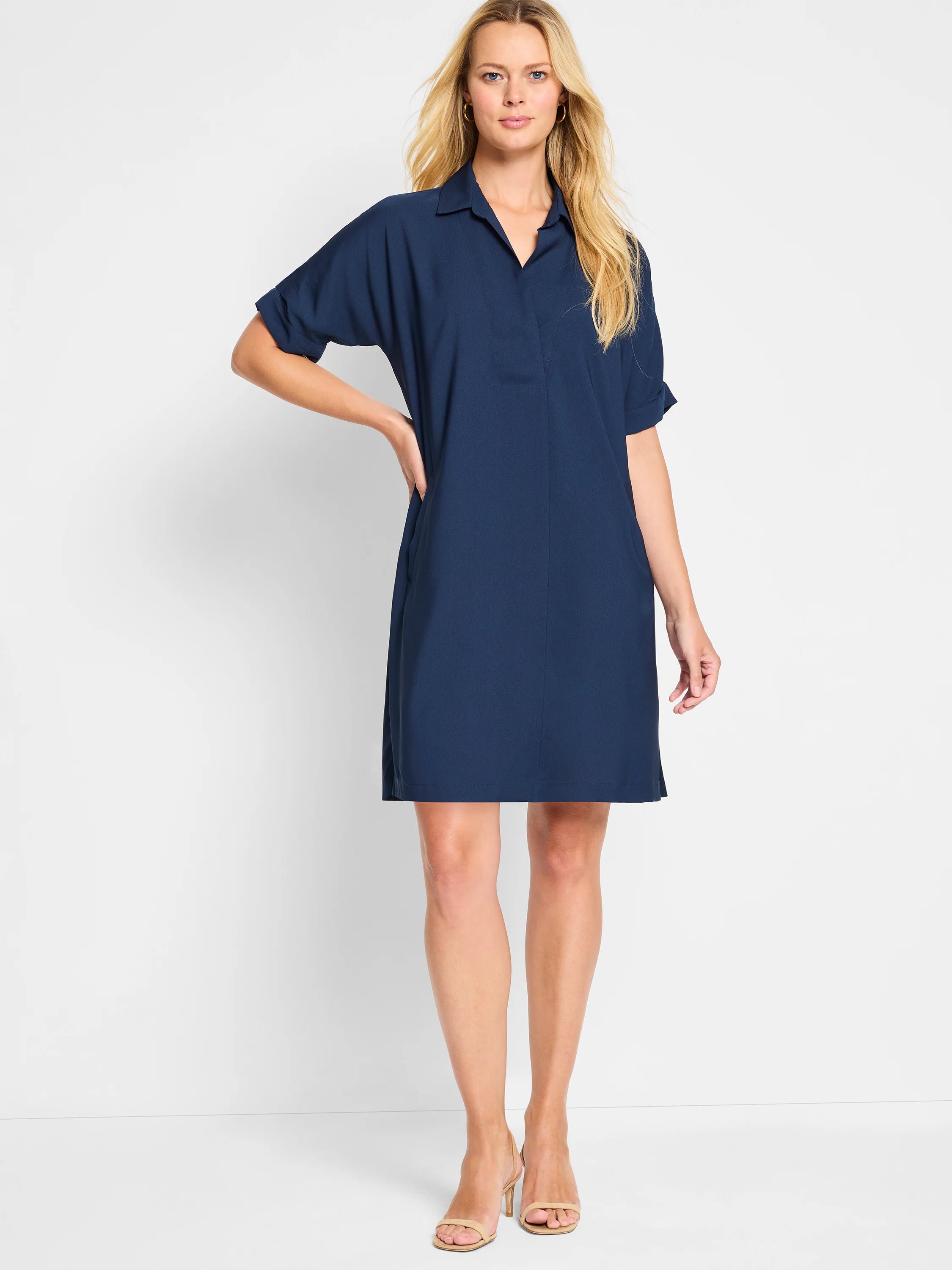 Navy blue dress with collared V-neck, cuffed short sleeves, side pockets, and above-knee length.