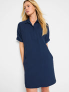 Dark blue shirt dress with a collar, V-neck, short cuffed sleeves, side pockets, and above-knee length.