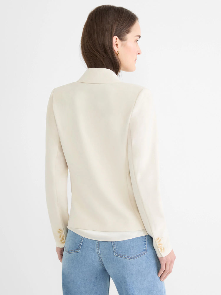 Fitted cream blazer, back view on a model, showing three light brown cuff buttons.