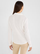 Model wears a slim off-white textured knit long-sleeve collared shirt.