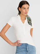 Off-white ribbed short-sleeve polo with a collar and a two-button front placket.