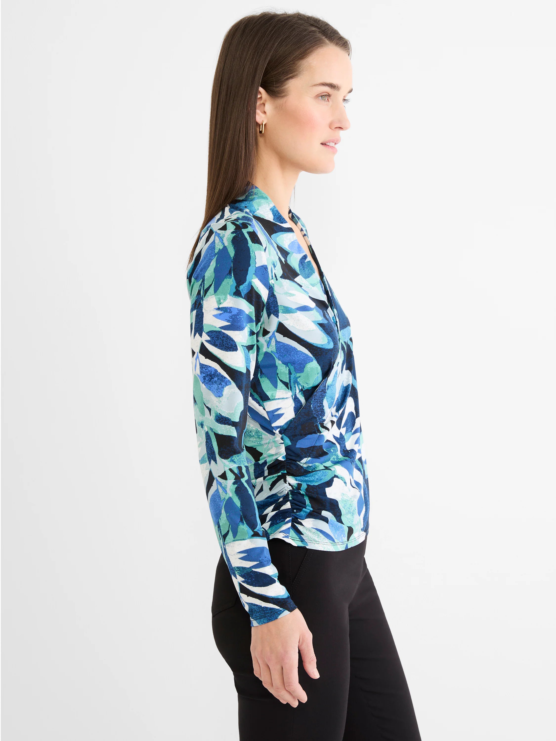 Blue, teal, white, black leaf print knit wrap top with a V-neckline and ruched side detail.