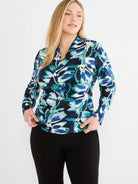 Knit wrap top with a blue, teal, & white leaf print on a dark background. Features a V-neck and long sleeves.