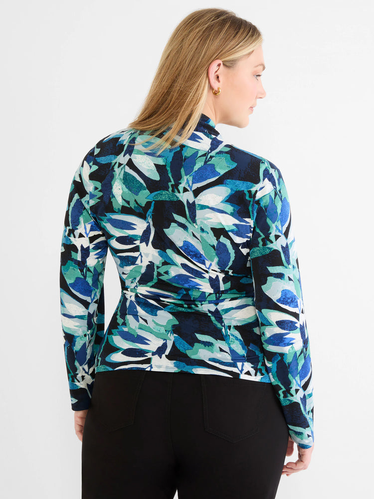 Knit wrap top with abstract print in shades of blue, teal, black, and white. Features long sleeves and a high neck.