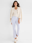 Light beige ribbed scoop tank top on a model, partially covered by an open jacket.