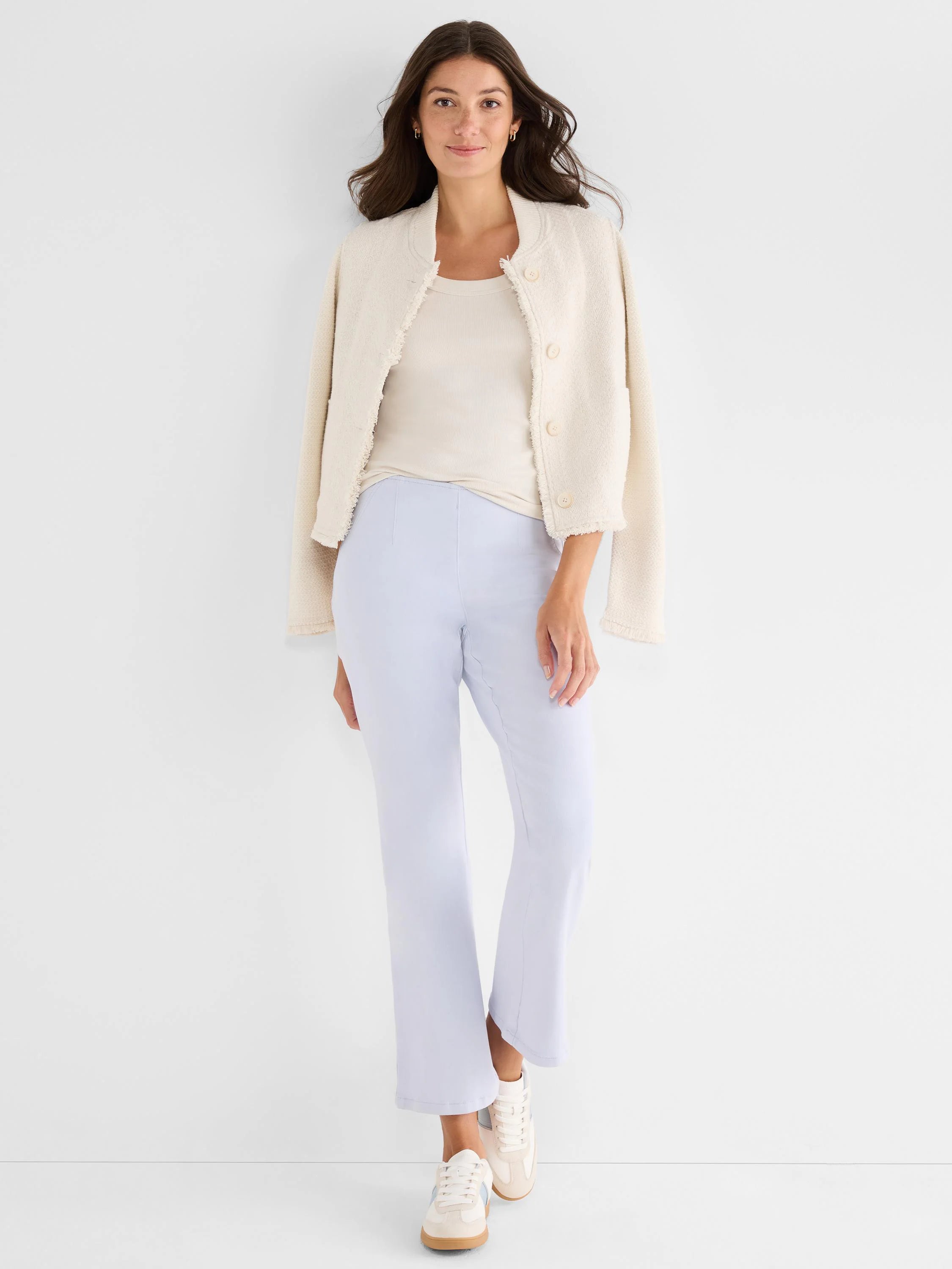 Light beige ribbed scoop tank top on a model, partially covered by an open jacket.